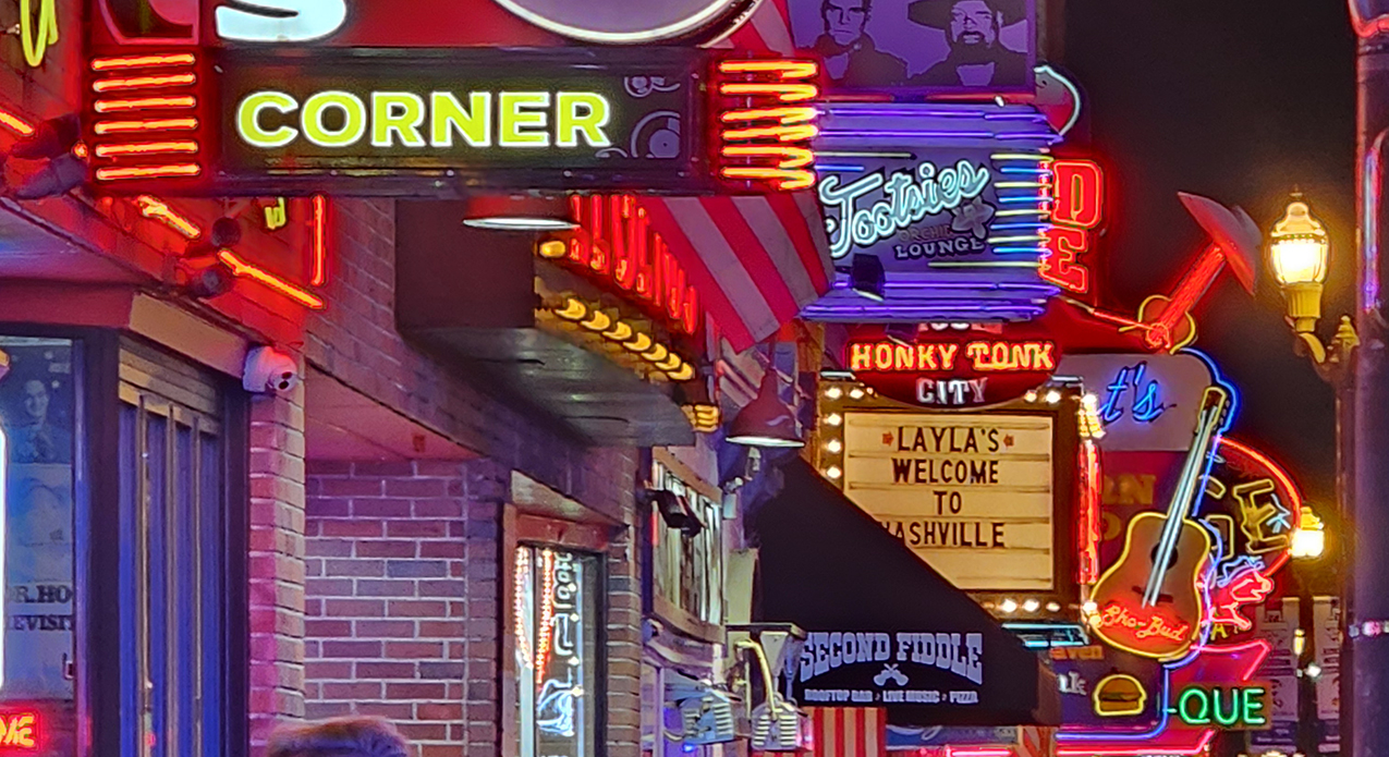 Classic neon dive bar sign glowing in downtown Nashville