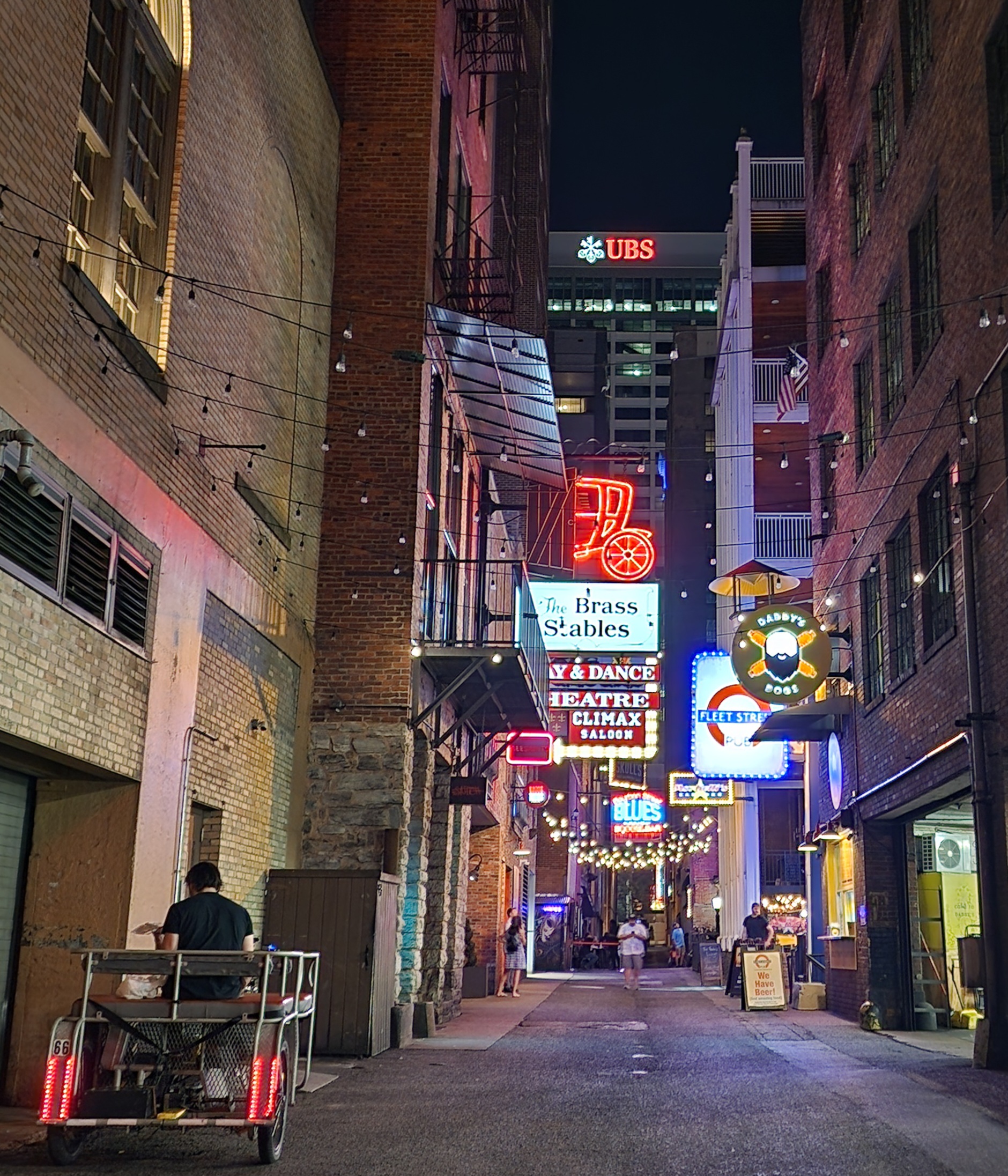Neon signs and bars glowing in Printer’s Alley at night