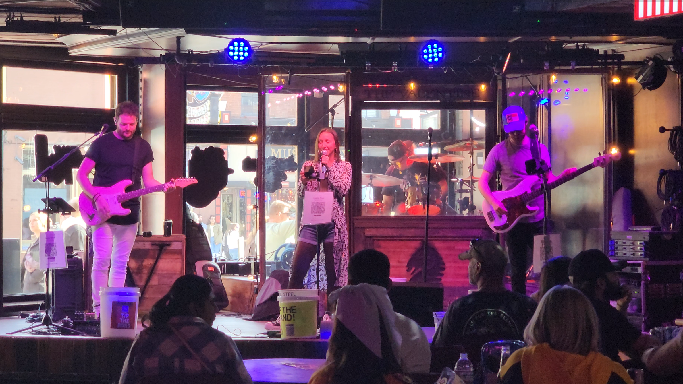 A live band performing inside a Lower Broadway honky-tonk as visitors watch from tables near the stage.