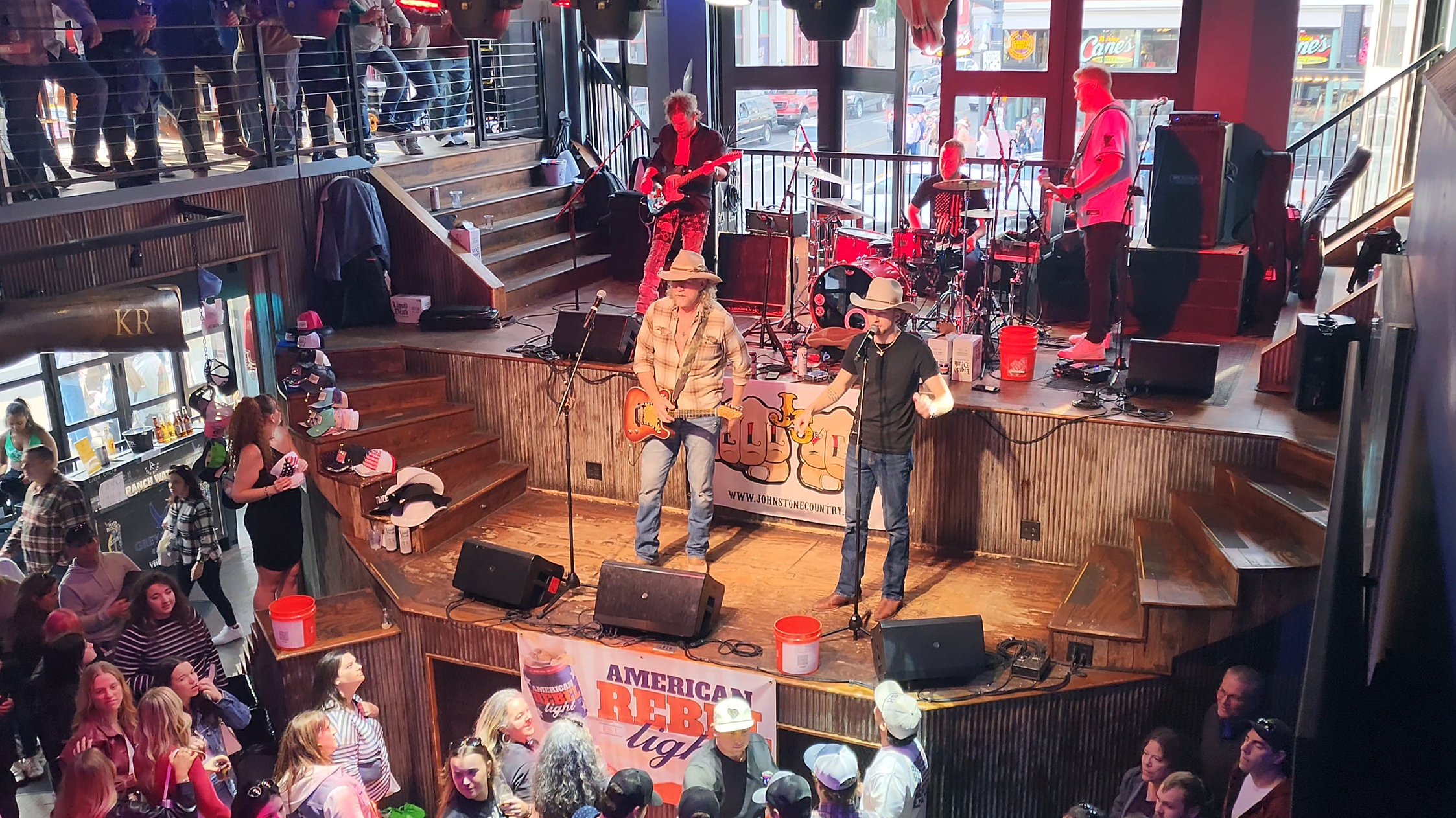 A live country band performing on two levels inside a Lower Broadway honky-tonk during the day.