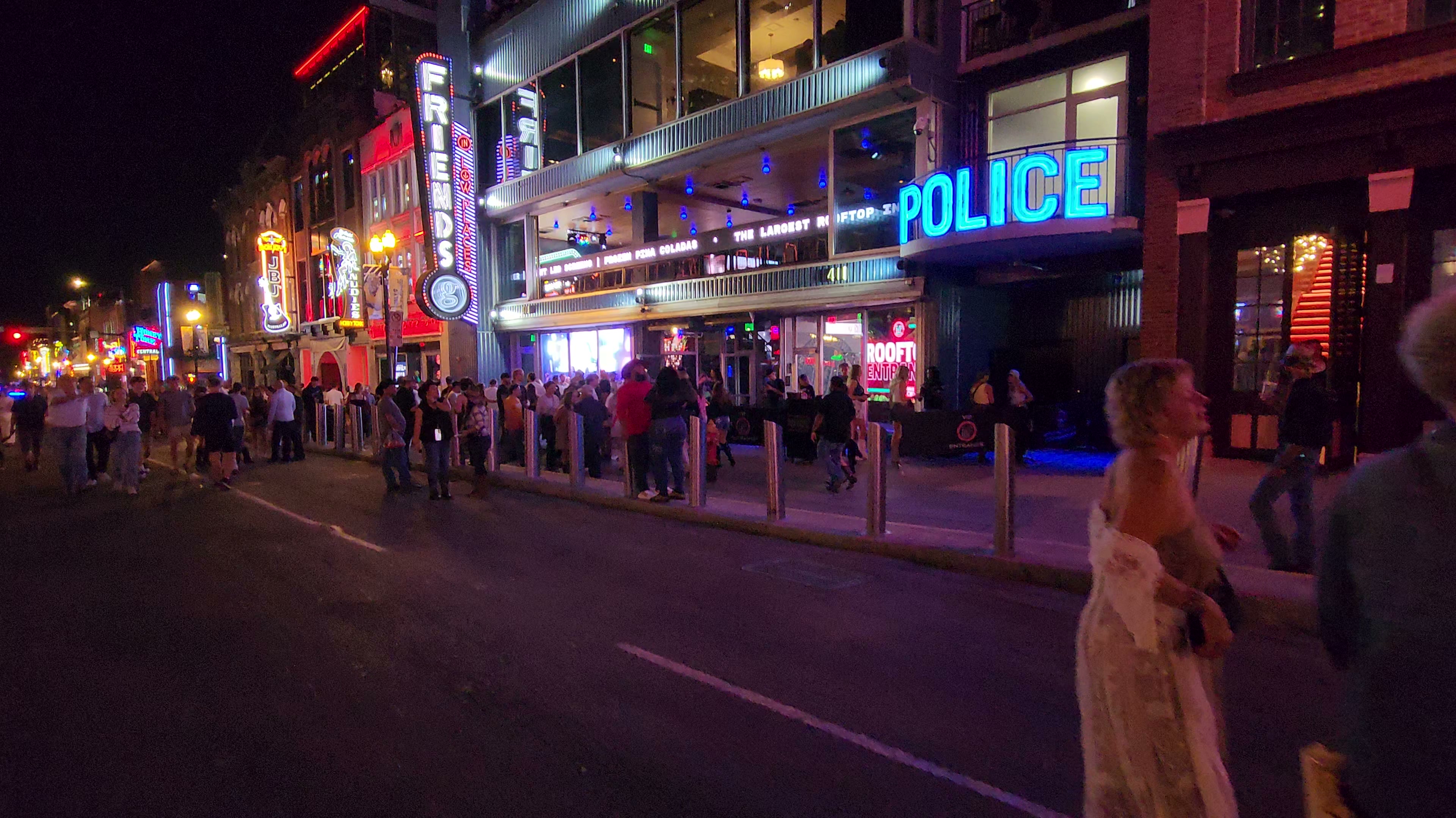 Police officers and vehicles on Lower Broadway at night.