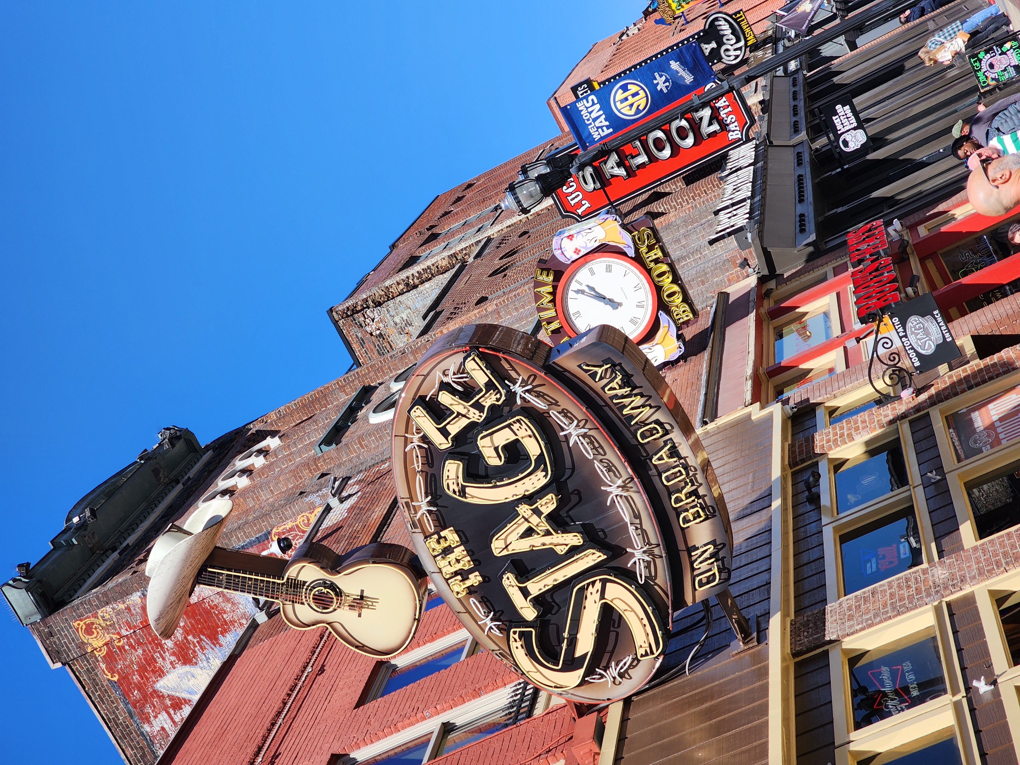 The Stage, Bootleggers Inn and neighboring Lower Broadway signs in daylight.