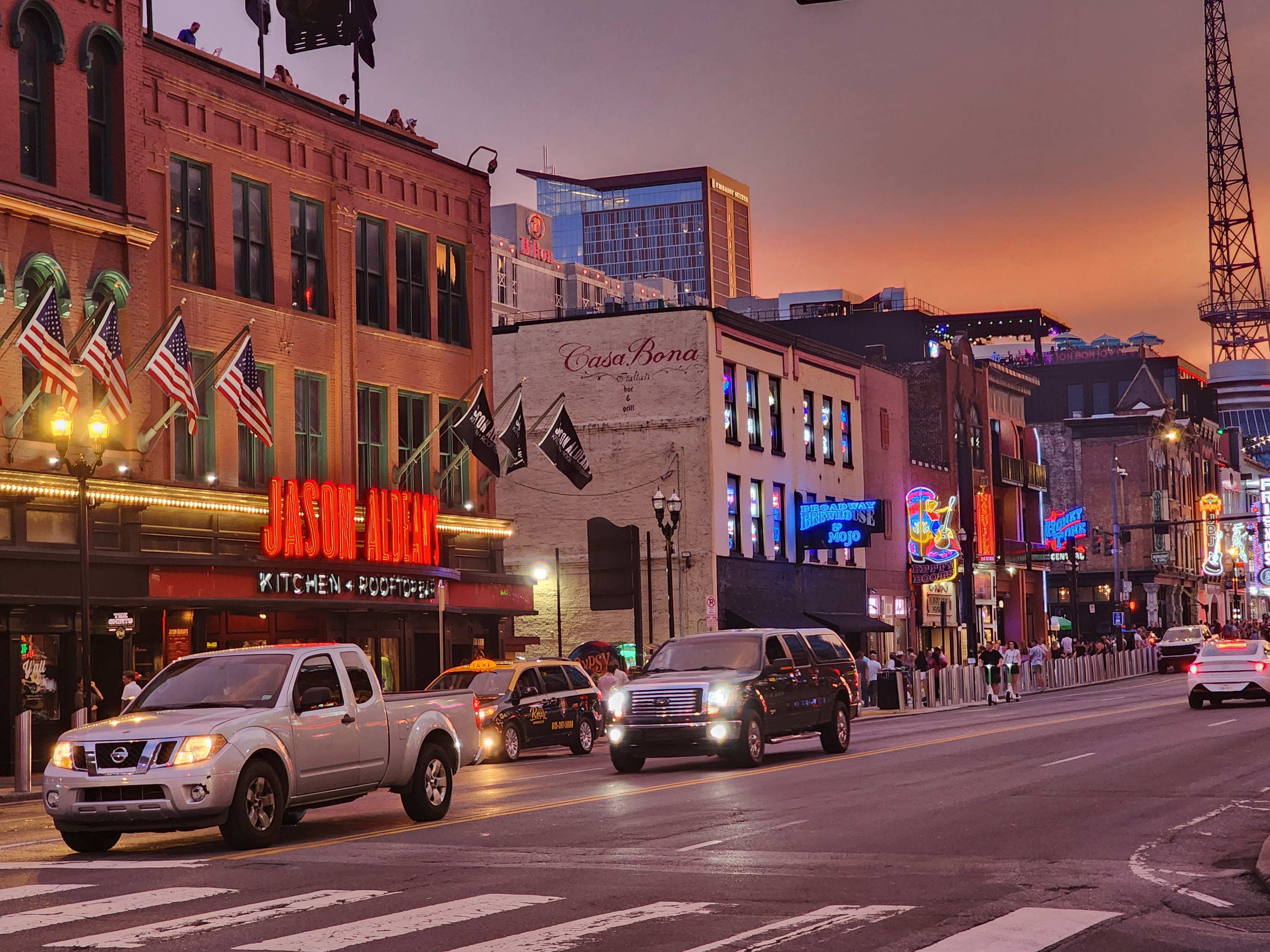 Artist-branded Lower Broadway venues illuminated at sunset.
