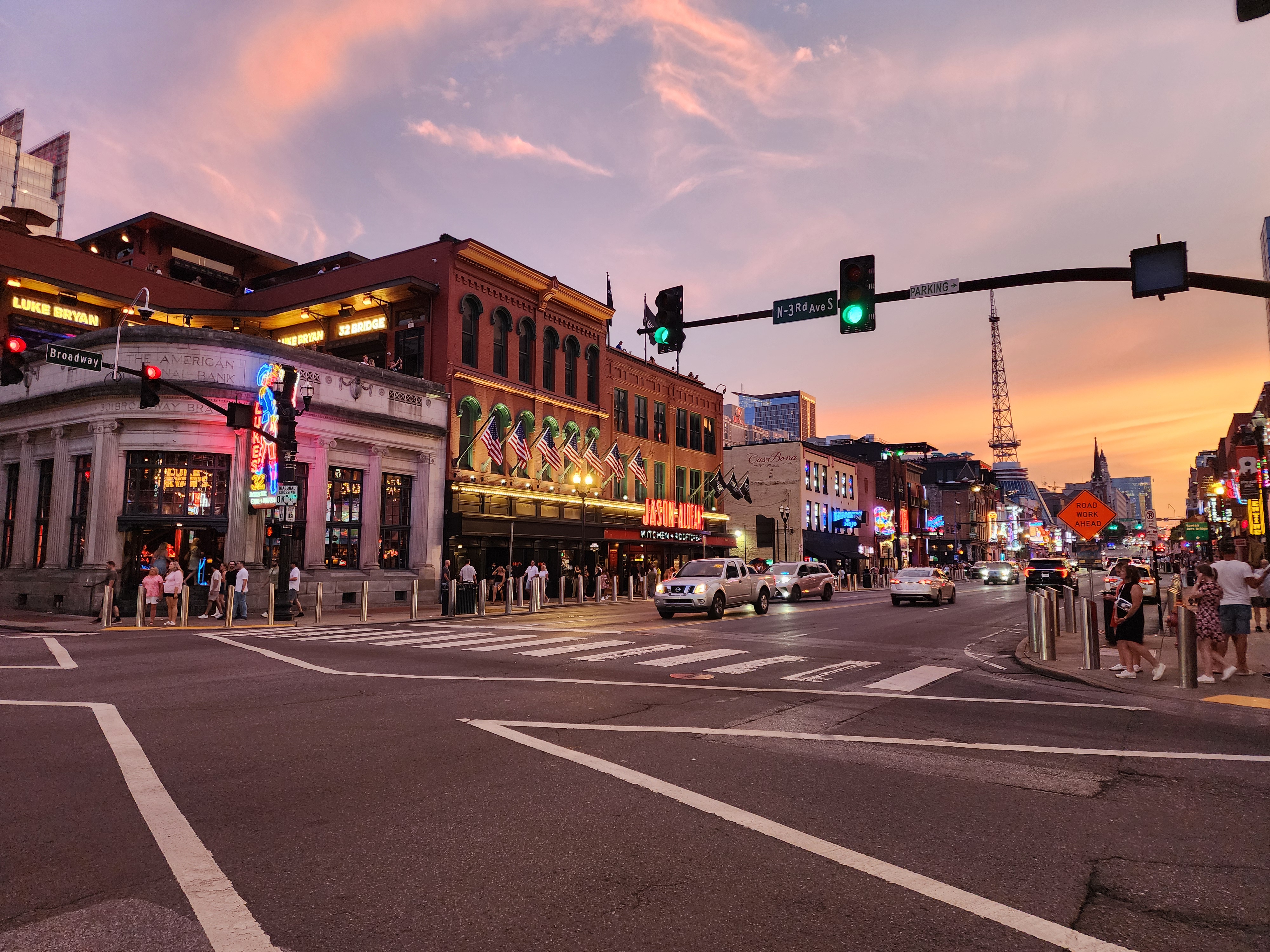 Lower Broadway bars lining the route toward the river at sunset.