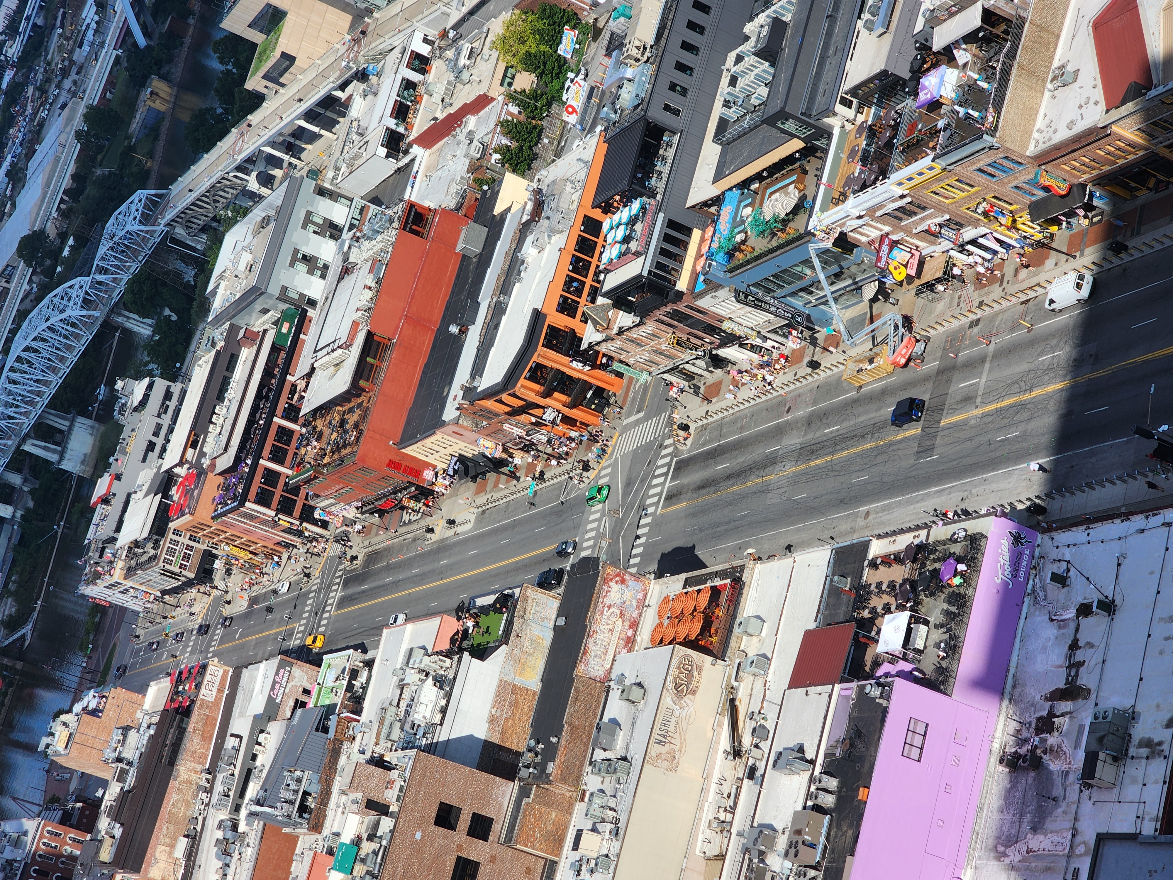 Lower Broadway viewed from above with the Cumberland River and bridge beyond the bar corridor.