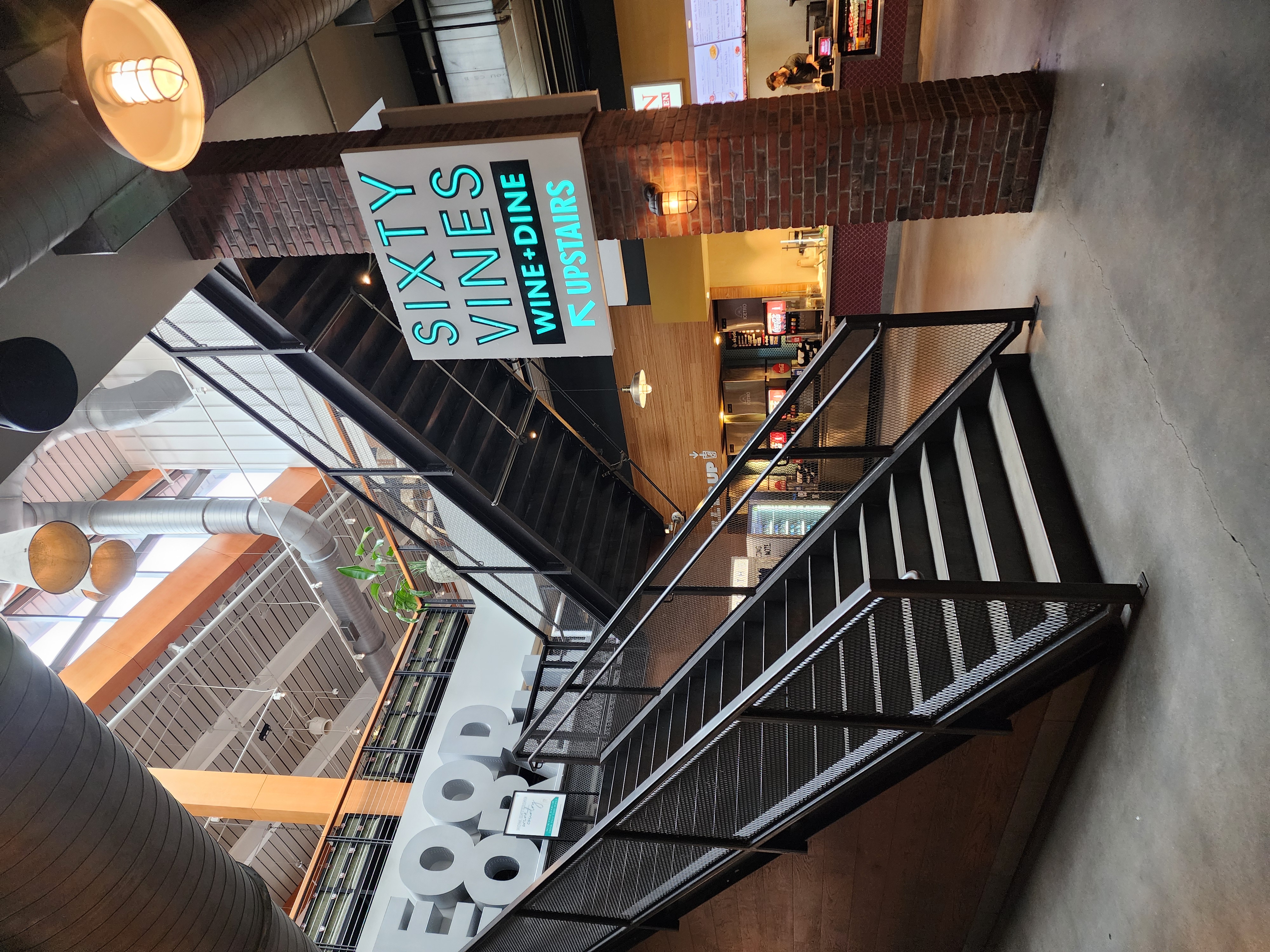 Stairs and restaurant signs inside Assembly Food Hall.