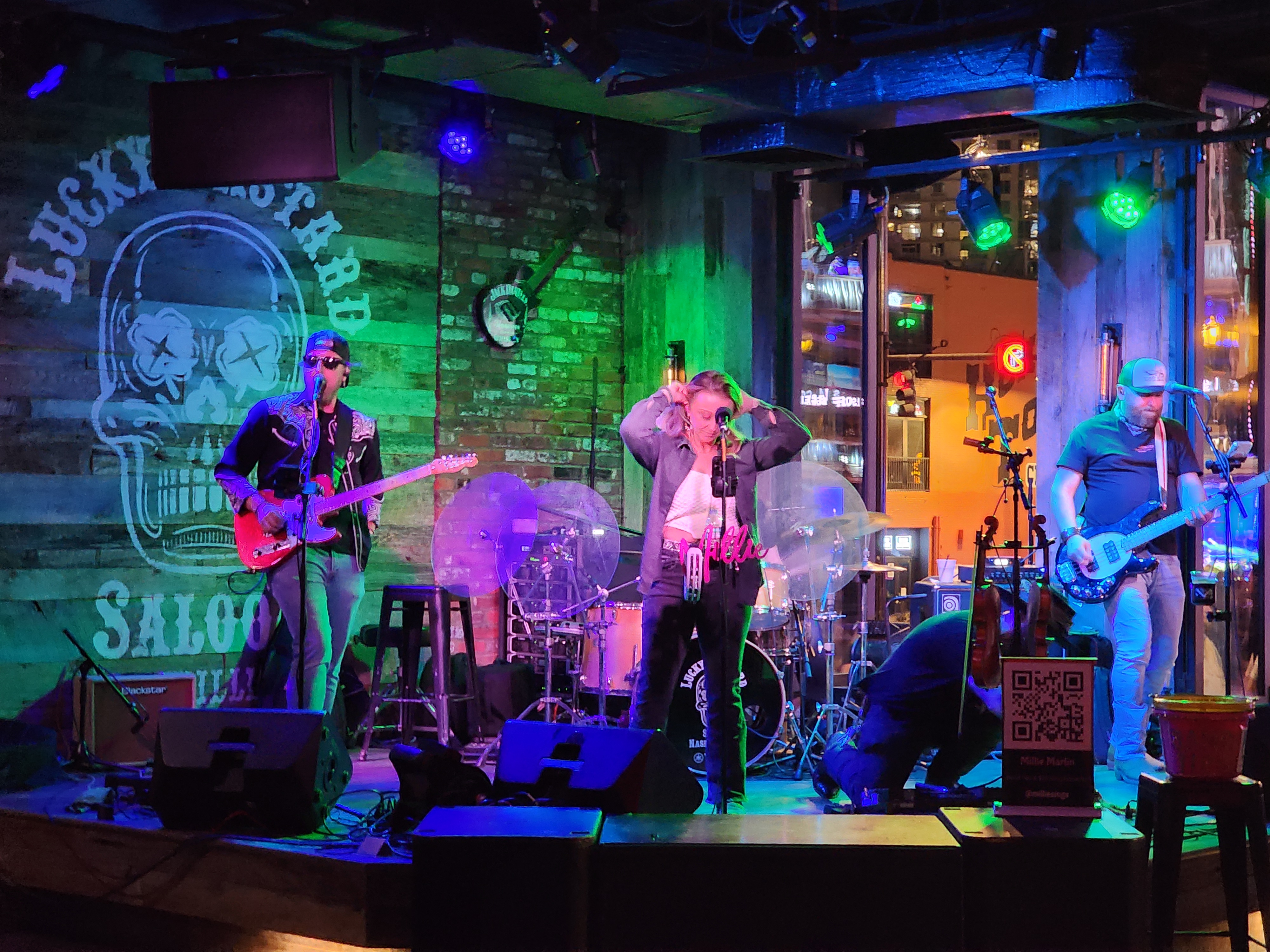 A full electric band performs live under colored stage lighting in Nashville.