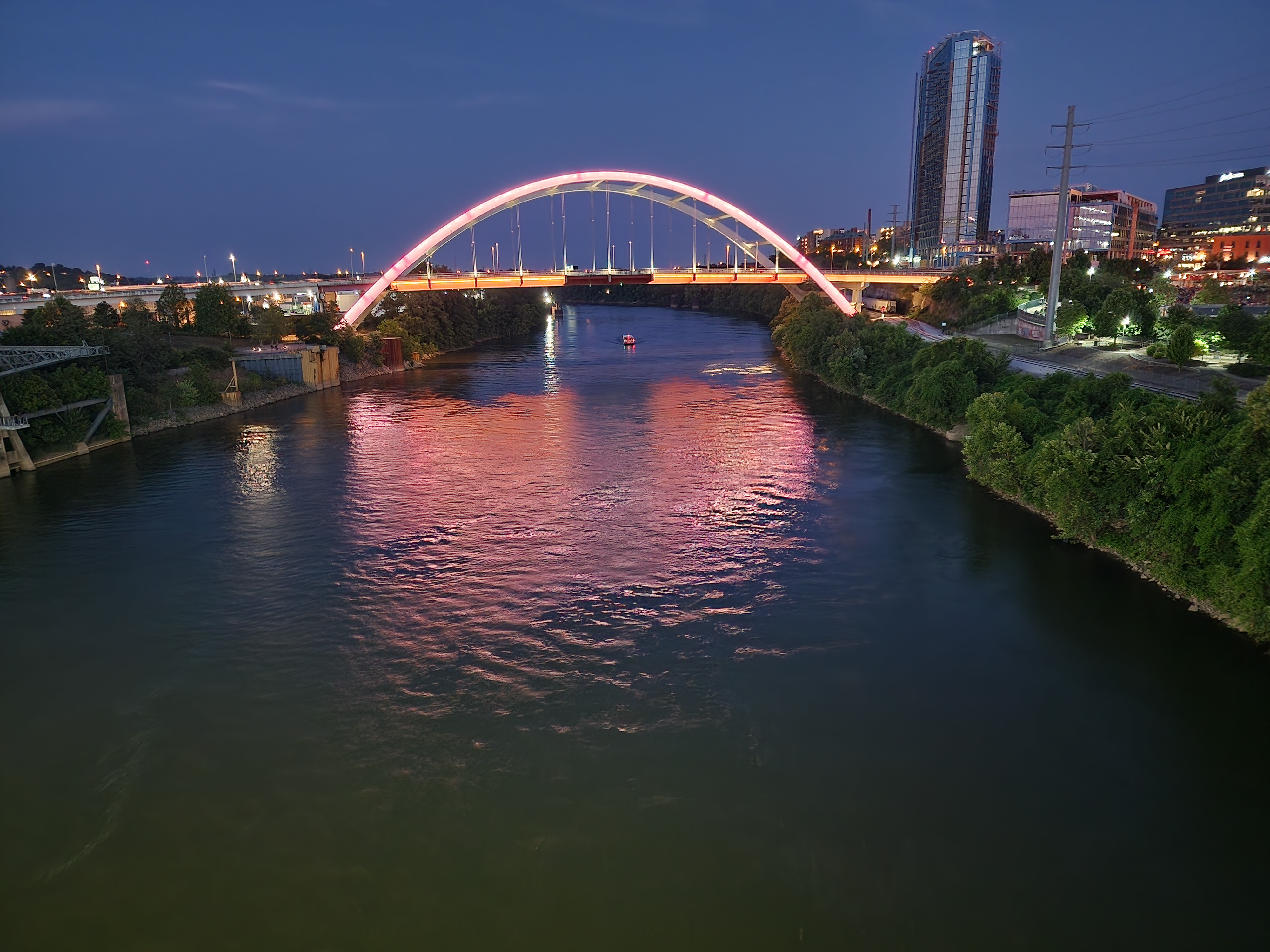 The Nashville skyline and pedestrian bridge at twilight.