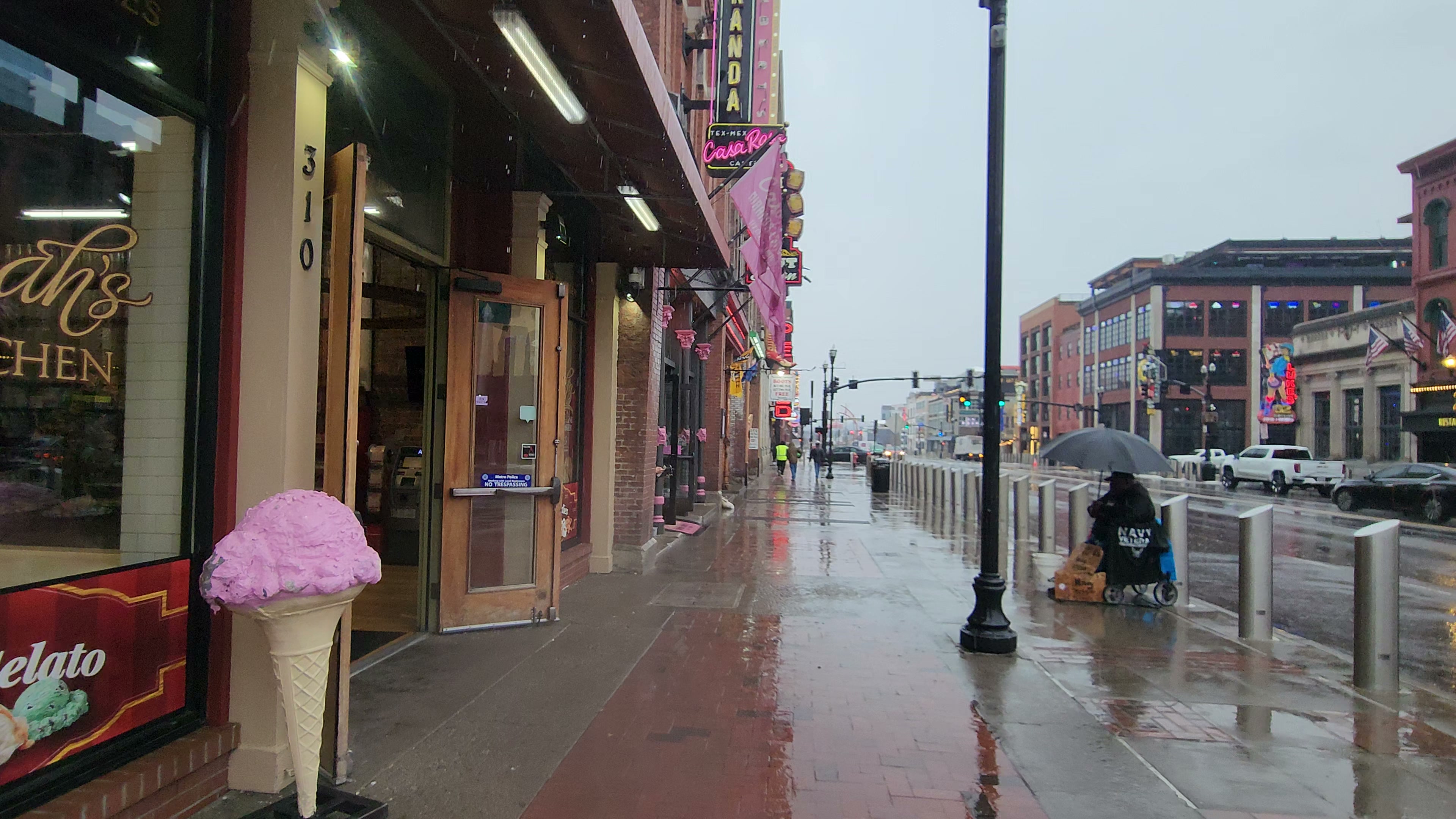 Lower Broadway and wet pavement during daytime rain.