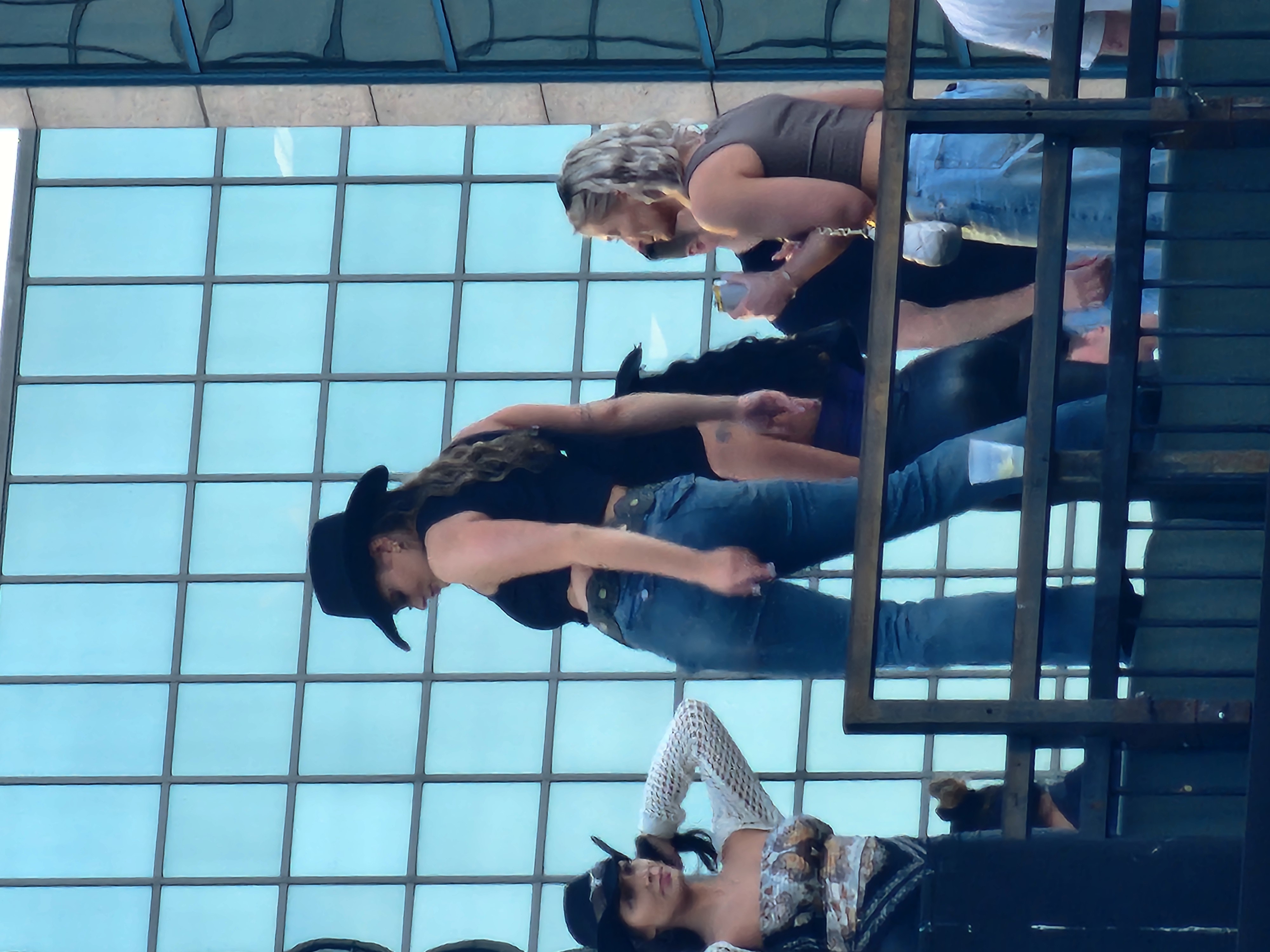 A performer and visitors on a daytime rooftop terrace in Nashville.