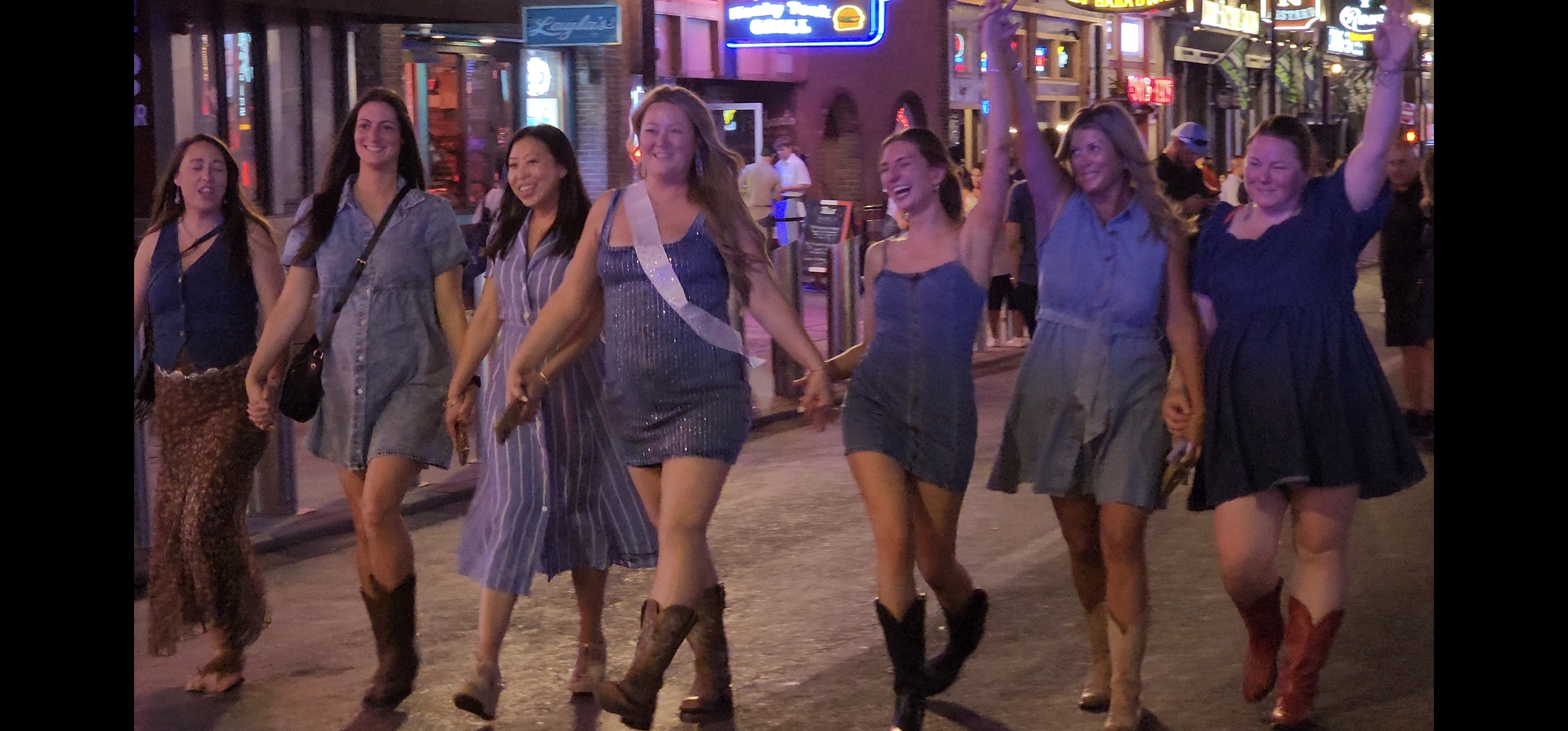 A group line-dances together inside a Nashville venue.