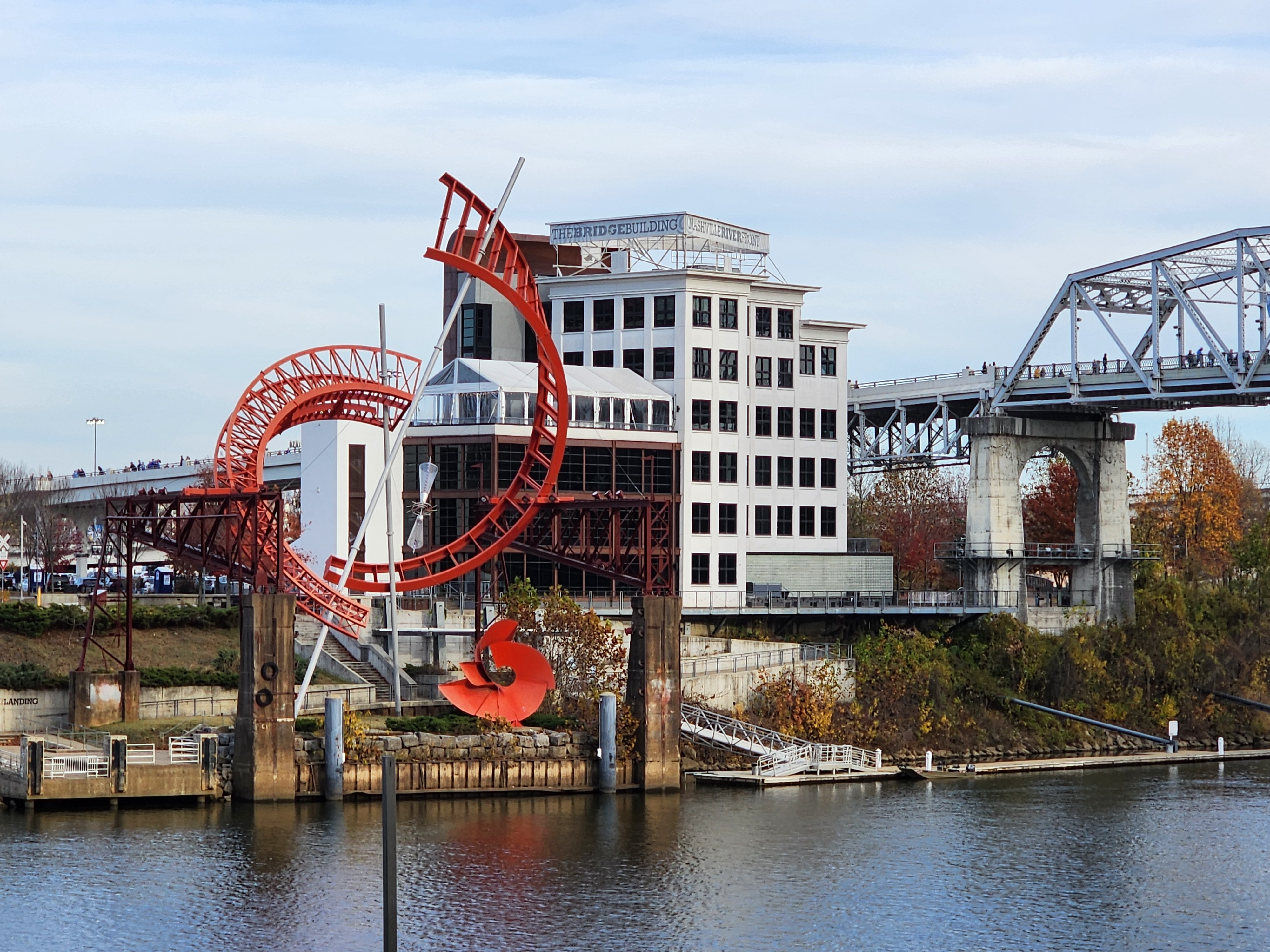 The downtown riverfront sculpture and pedestrian bridge in daylight.