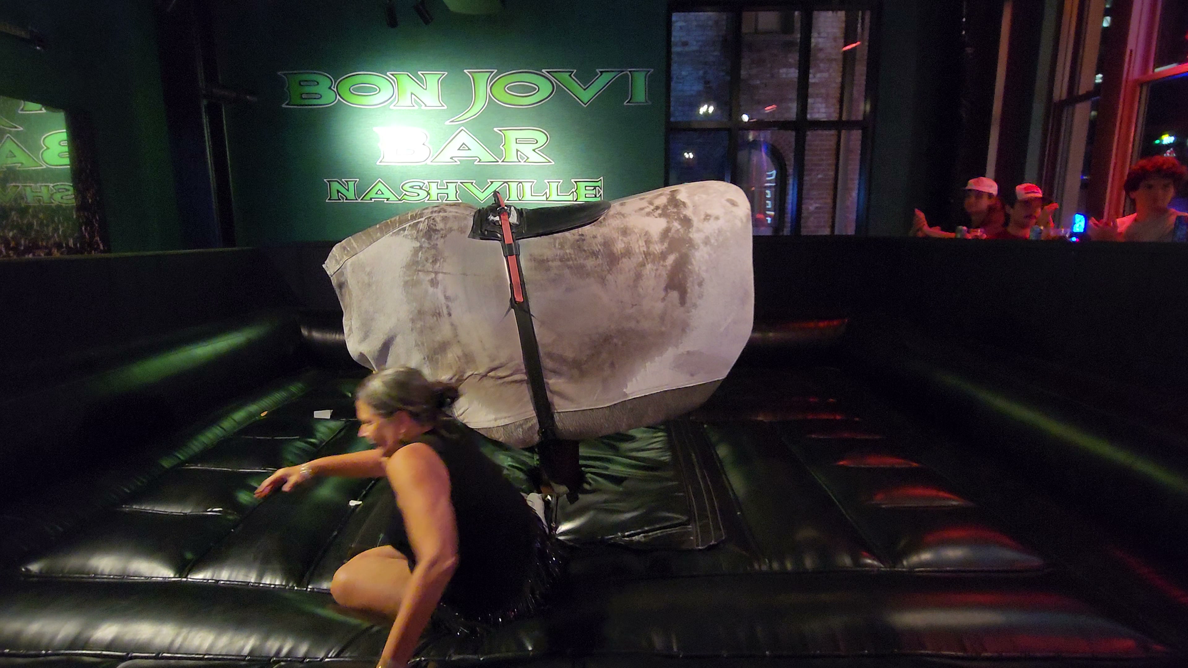 A rider holds on to a mechanical bull inside a Nashville venue.