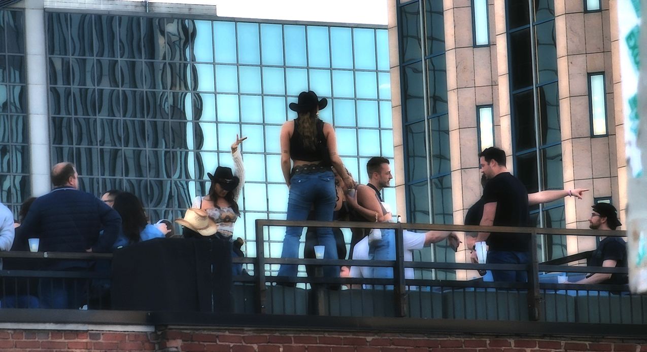 Cowgirls and crowd on Broadway honky tonk rooftop